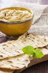 Hummus in a bowl and pita bread