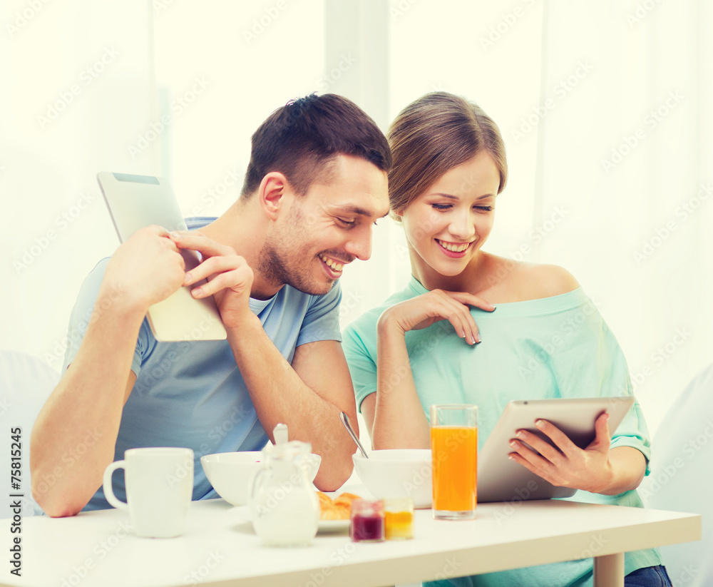 Poster smiling couple with tablet pc reading news