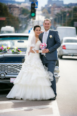 bride and groom on the street near the retro car