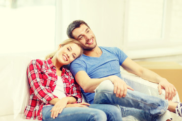 smiling couple relaxing on sofa in new home