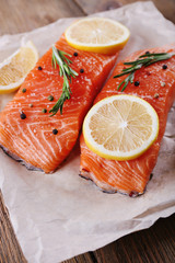 Fresh salmon with spices and lemon on wooden table