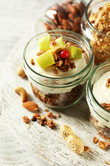 Healthy layered dessert with muesli and fruits on table