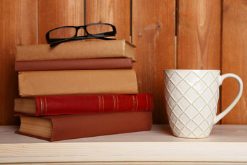 Pile of books with cup and glasses