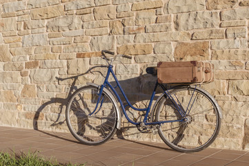 Fototapeta na wymiar Vintage bicycle and old suitcase in a stone wall