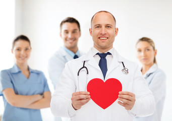 Fototapeta premium smiling male doctor with red heart and stethoscope