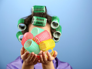 Girl in hair curlers on colorful background