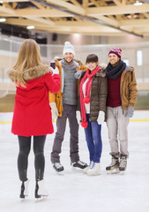 happy friends taking photo on skating rink