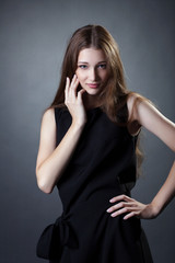 Fototapeta premium Pretty young girl posing in trendy black dress