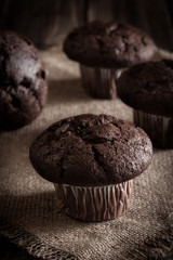 Chocolate cake muffins on a table. Dark lighting