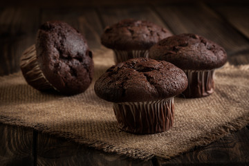 Chocolate cake muffins on a table. Dark lighting