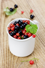 black currant and red currant in a white cup