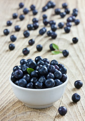 blueberries in the white bowl on a wood rustic background