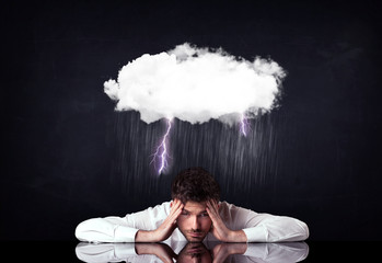 Depressed businessman sitting under a cloud