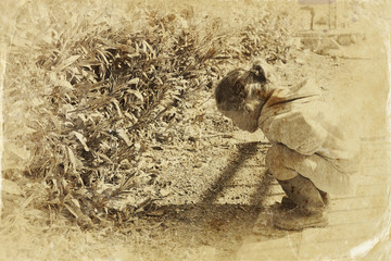 cute little girl playing in the garden. filtered image, old styl