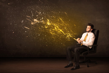 Businessman with tablet and energy explosion on background