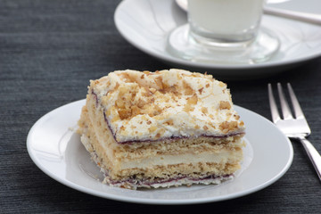 Piece of layered cake on white plate.