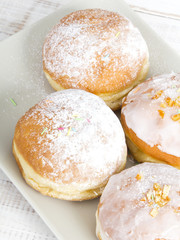 donuts with frosting and powdered sugar on a platter