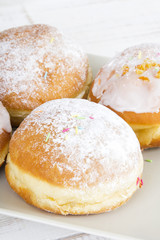 donuts with frosting and powdered sugar on a platter