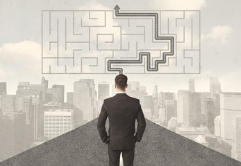 Businessman looking at road with maze and solution