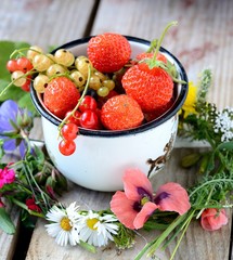 mug  with fresh berries on black stone background