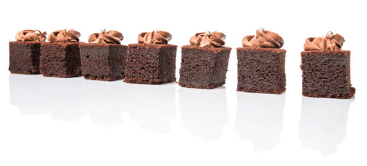 Bite sized chocolate cake with icing on top over white 