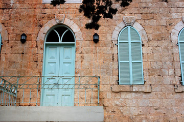 Fototapeta na wymiar old house wall from jerusalem stone with old blue balcony