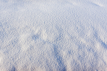 Texture of white snow with blue shadows