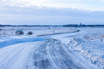 Fototapeta premium Countryside road through winter field