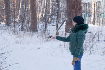 Fototapeta na wymiar Girl lure protein in the winter forest.