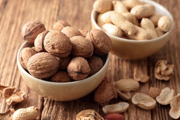 Heap of walnuts in a bowl and broken shells around
