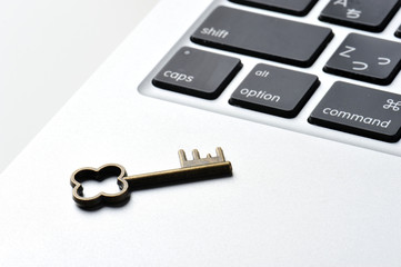 パソコンのキーボードと小さな鍵の写真,個人情報保護のイメージ
