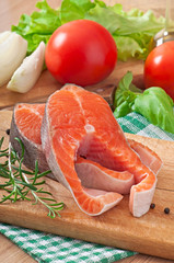 Fresh and raw steaks trout on a wooden cutting board 
