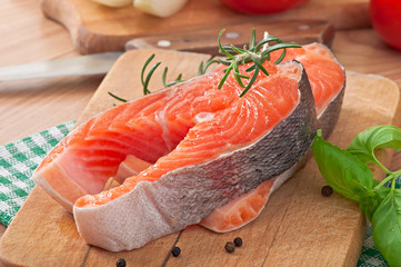 Fresh and raw steaks trout on a wooden cutting board 