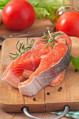 Fresh and raw steaks trout on a wooden cutting board 