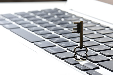 パソコンのキーボードと小さな鍵の写真,個人情報保護のイメージ