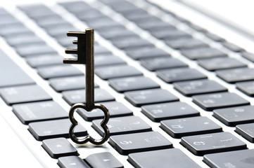 パソコンのキーボードと小さな鍵の写真,個人情報保護のイメージ