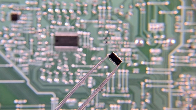 Chip tweezers through the lens to the circuit Board background