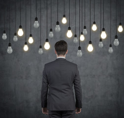 Obraz premium businessman looking to light bulbs