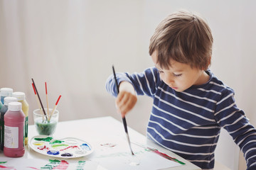 Cute little boy painting in his album © Tomsickova