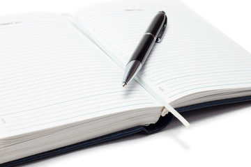 opened business diary with a pen over white background