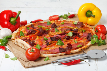Pizza with ham, salami, pepper and tomato