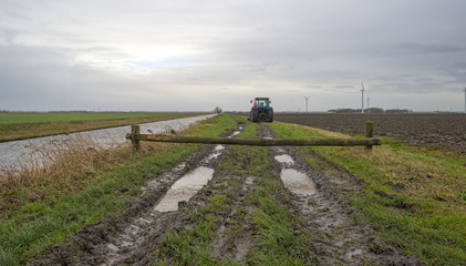 Fototapeta premium Tractor parked along a canal in winter