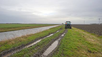 Tractor parked along a canal in winter