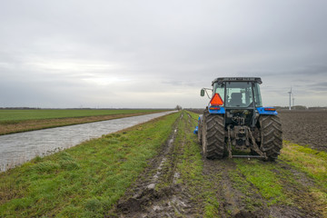 Obraz premium Tractor parked along a canal in winter
