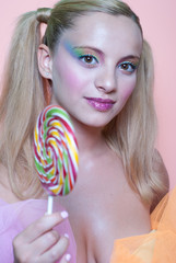 Girl holding a lolly pop, in pink background