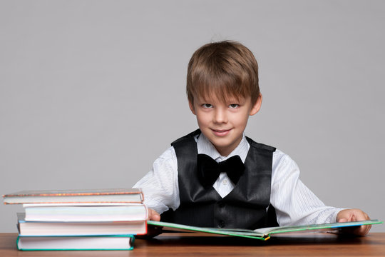 Young Boy At The Desk Reads A Book