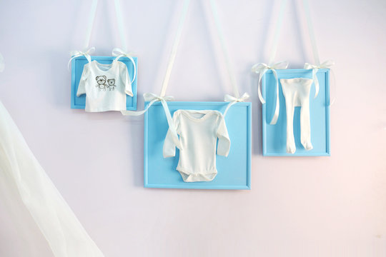 Blue baby clothes on the clothesline ribbons on the wall