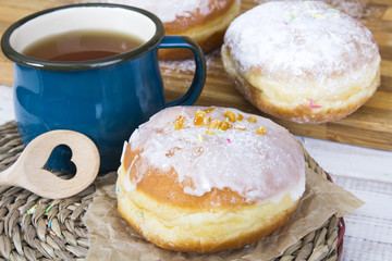 Classic glazed doughnuts and mug of tea