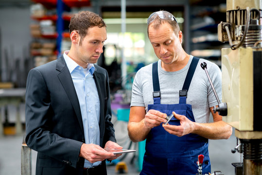 in the factory- young boss and worker in conversation