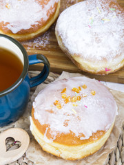 Classic glazed doughnuts and mug of tea